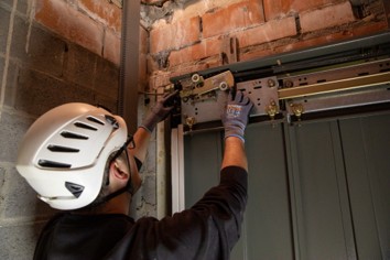 Technische controle van liftcomponenten door een controleur bij een liftinstallatie Inspecteur effectuant un contrôle technique des composants d’une installation d’ascenseur